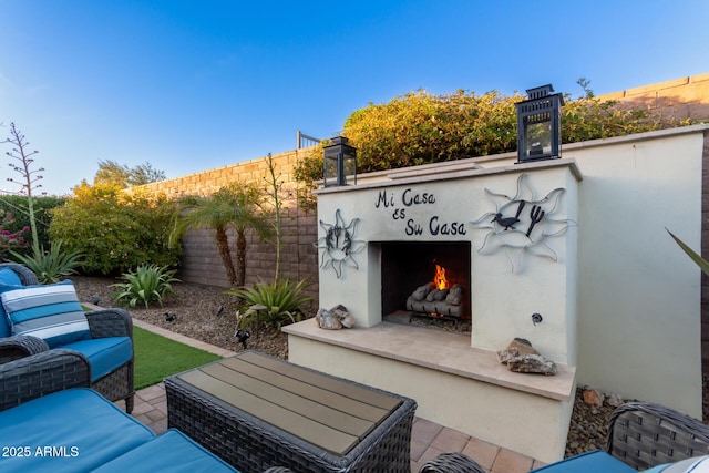 view of patio with an outdoor living space with a fireplace