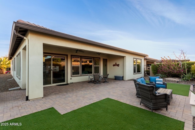 back of property featuring ceiling fan, a yard, an outdoor hangout area, and a patio area