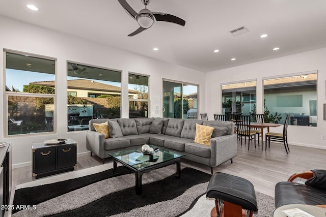 living room with ceiling fan, light hardwood / wood-style floors, and a healthy amount of sunlight