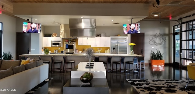 kitchen with white cabinetry, stainless steel appliances, a breakfast bar, and wooden ceiling