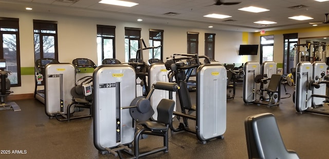 workout area with a paneled ceiling and a healthy amount of sunlight