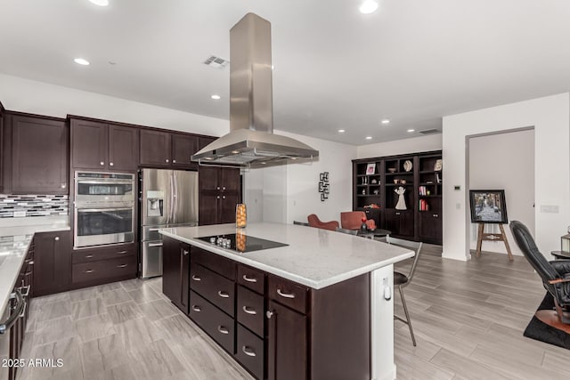 kitchen with a breakfast bar area, a center island, dark brown cabinets, appliances with stainless steel finishes, and island exhaust hood