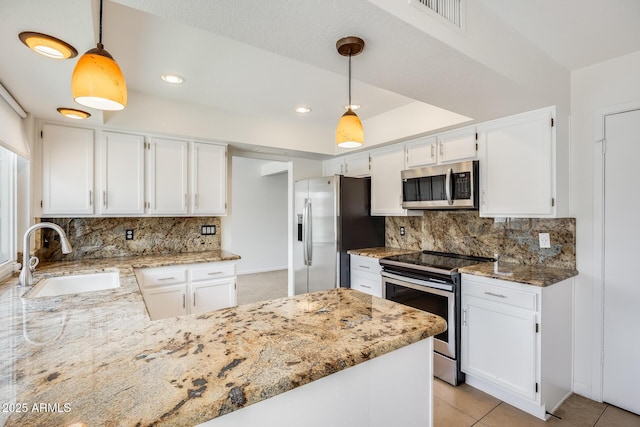 kitchen featuring a sink, light stone countertops, appliances with stainless steel finishes, and white cabinetry