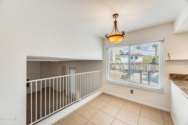 unfurnished dining area with light tile patterned floors and baseboards