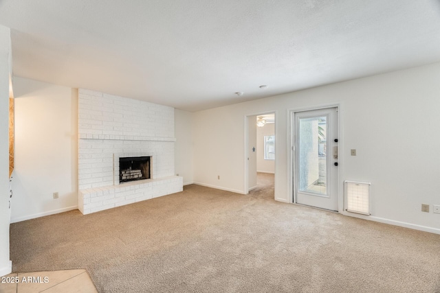 unfurnished living room featuring carpet flooring, a fireplace, and baseboards