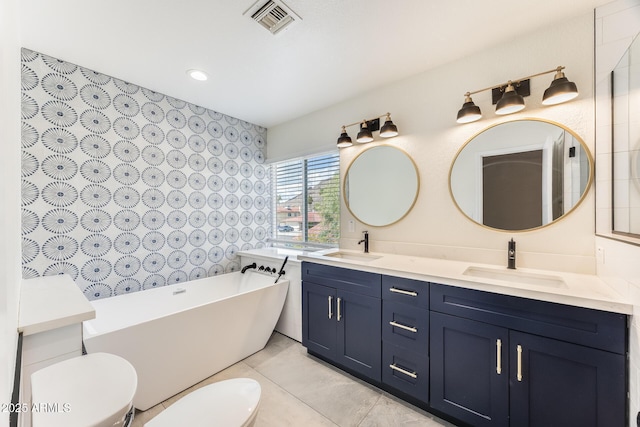 bathroom featuring a soaking tub, visible vents, toilet, and a sink