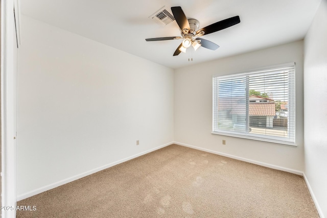 unfurnished room with visible vents, light carpet, baseboards, and ceiling fan