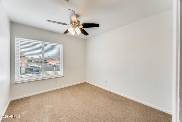 carpeted empty room featuring baseboards and ceiling fan