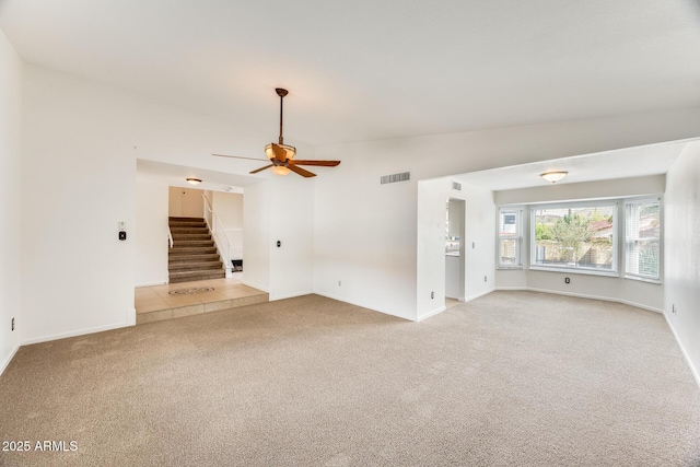 unfurnished living room with visible vents, light colored carpet, stairs, lofted ceiling, and a ceiling fan