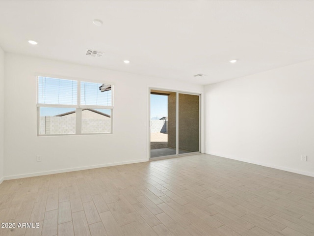 unfurnished room featuring visible vents, plenty of natural light, and light wood finished floors