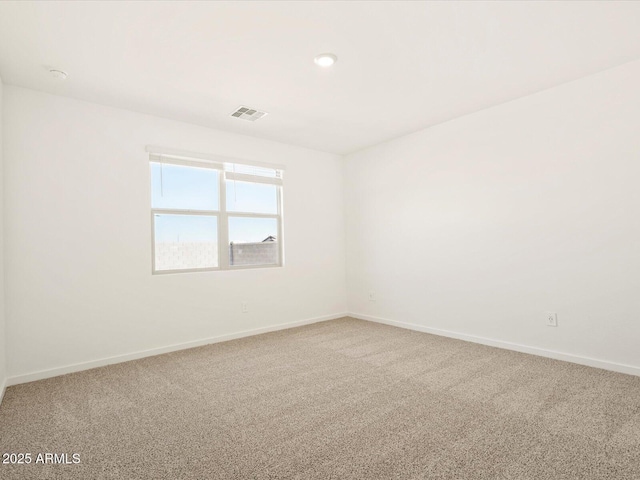 carpeted empty room featuring visible vents and baseboards