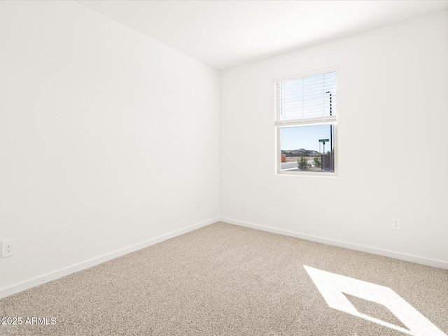 spare room with carpet and baseboards