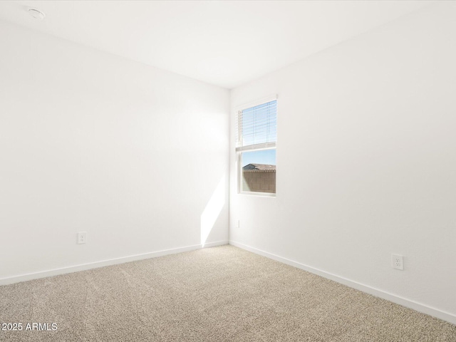 empty room featuring baseboards and carpet flooring