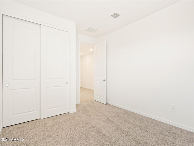 unfurnished bedroom featuring a closet, carpet flooring, baseboards, and visible vents