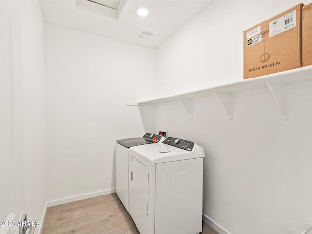 clothes washing area with baseboards, laundry area, recessed lighting, washing machine and dryer, and light wood-type flooring