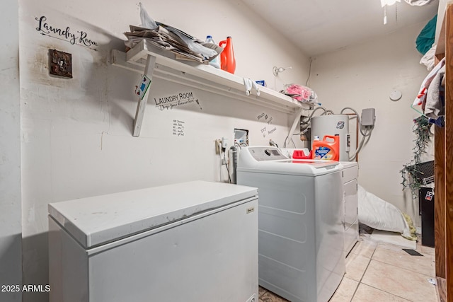 laundry area with laundry area, light tile patterned flooring, independent washer and dryer, and electric water heater