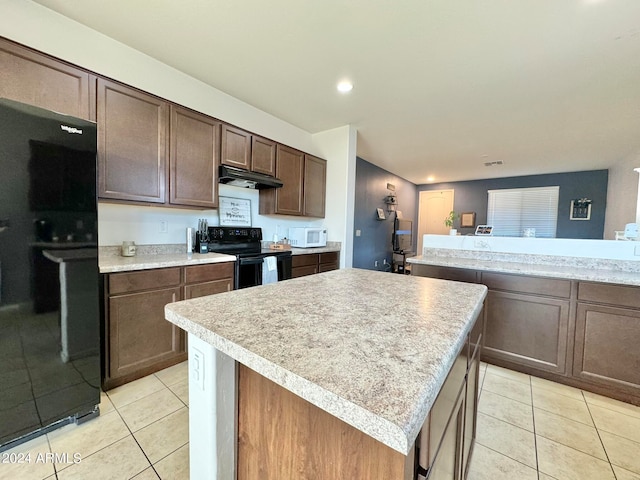 kitchen with black appliances, light tile patterned flooring, a center island, and dark brown cabinetry