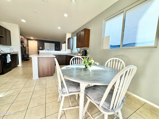 dining space featuring sink and light tile patterned floors