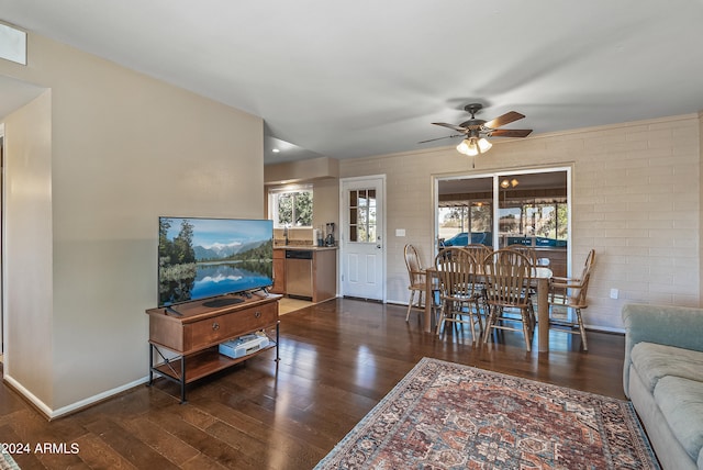 living room with ceiling fan, brick wall, and dark hardwood / wood-style flooring