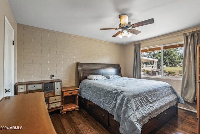 bedroom with brick wall, dark hardwood / wood-style floors, and ceiling fan