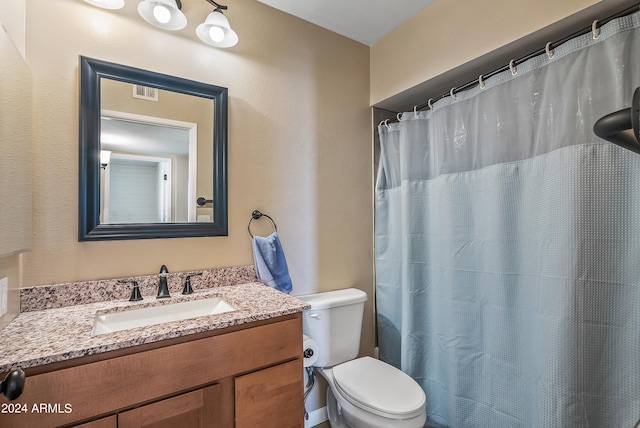 bathroom featuring vanity, toilet, and walk in shower