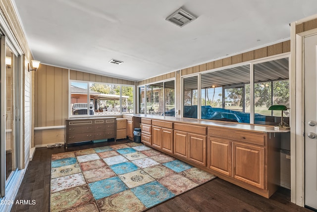 kitchen with lofted ceiling, wooden walls, ornamental molding, and dark hardwood / wood-style flooring