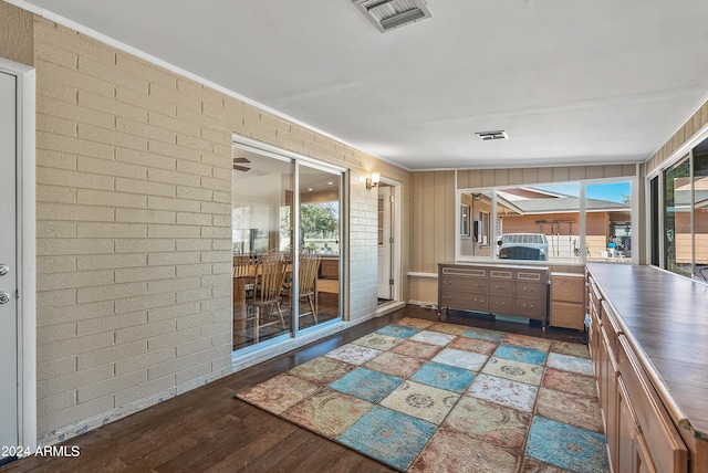 kitchen featuring dark wood-type flooring and brick wall