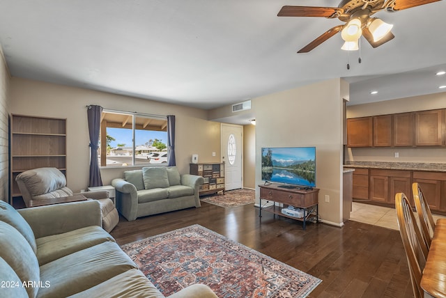 living room with ceiling fan and dark hardwood / wood-style flooring