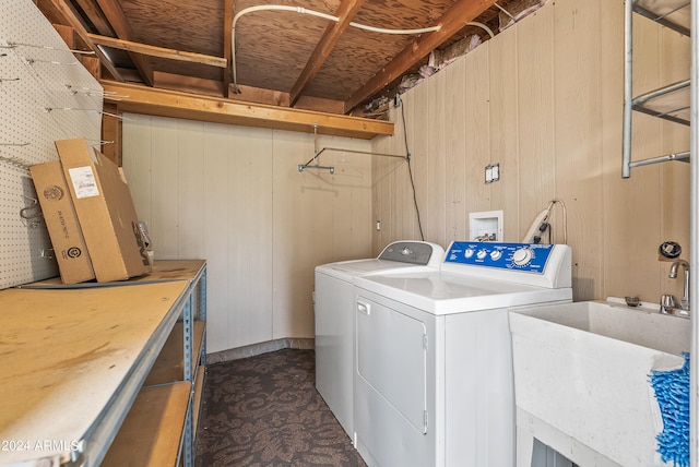 washroom featuring sink, washing machine and clothes dryer, and wooden walls