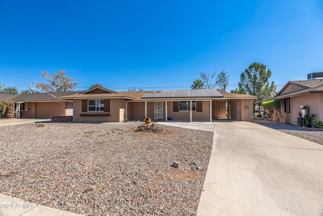 single story home with solar panels and a garage