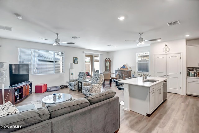 living room featuring sink, ceiling fan, and light hardwood / wood-style floors