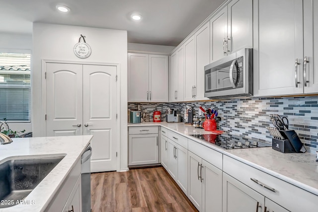 kitchen featuring white cabinetry, sink, backsplash, and appliances with stainless steel finishes