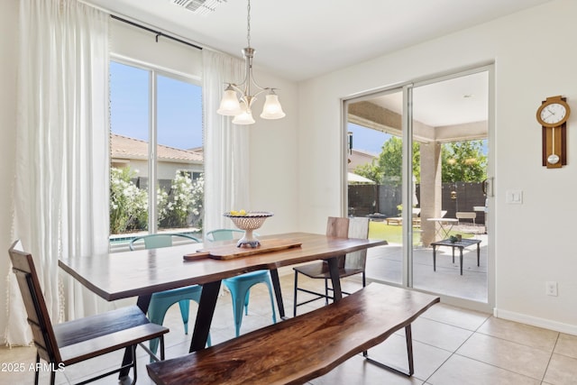 dining space featuring a chandelier, light tile patterned floors, and baseboards