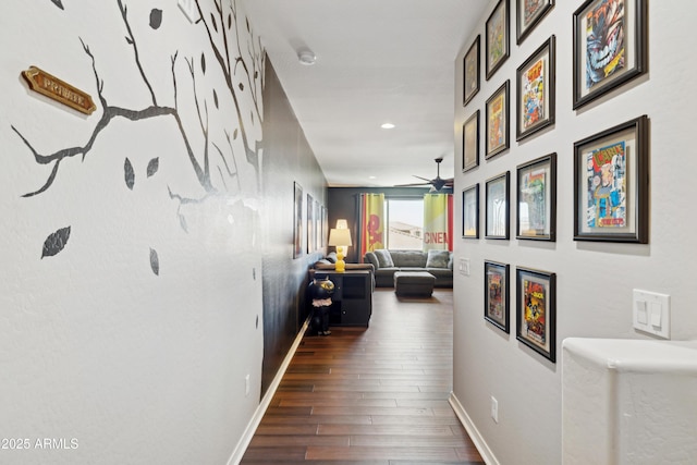 corridor with wood finished floors, baseboards, and recessed lighting