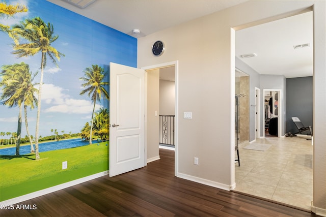 unfurnished bedroom with a water view, baseboards, and wood finished floors