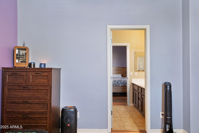 bedroom featuring light tile patterned floors and baseboards
