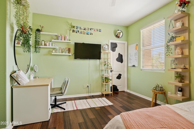 bedroom featuring baseboards, wood finished floors, and a desk