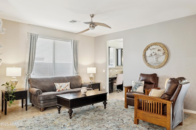 living area with plenty of natural light, ceiling fan, light tile patterned floors, and baseboards