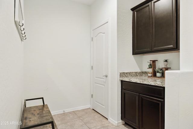bar with light tile patterned floors and baseboards
