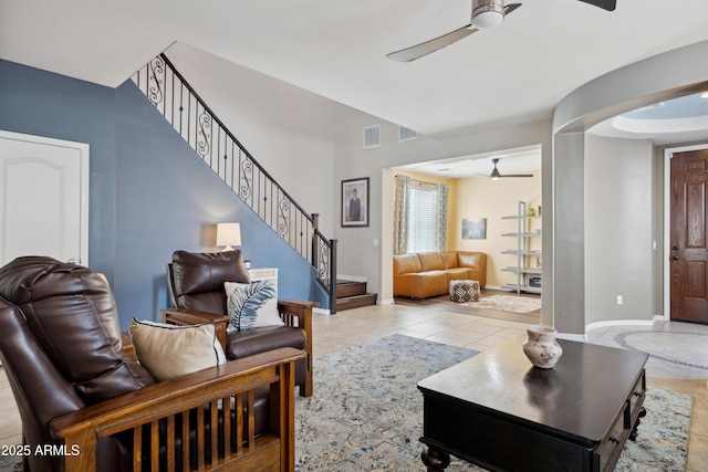 living room with ceiling fan, stairway, baseboards, and tile patterned floors