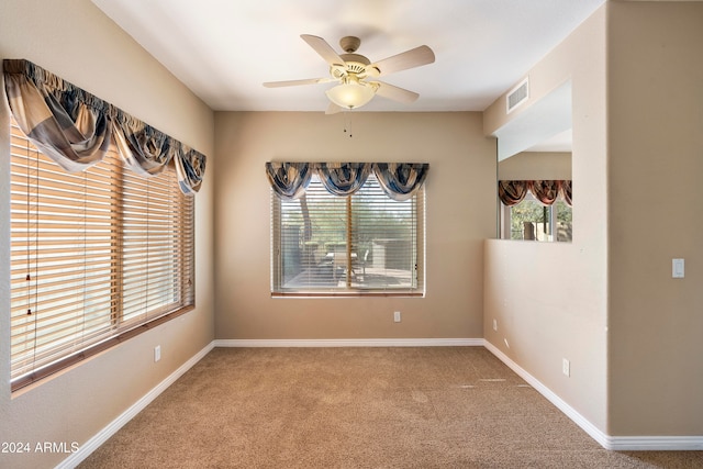 carpeted spare room with ceiling fan