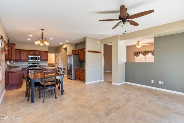 dining room featuring sink and ceiling fan with notable chandelier