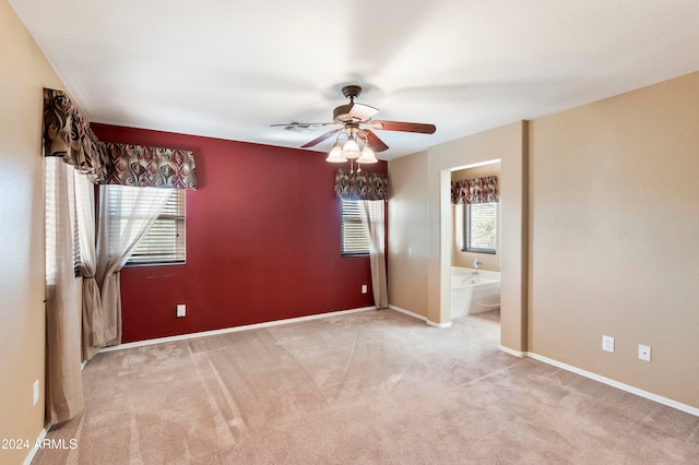 unfurnished room featuring light colored carpet, a healthy amount of sunlight, and ceiling fan