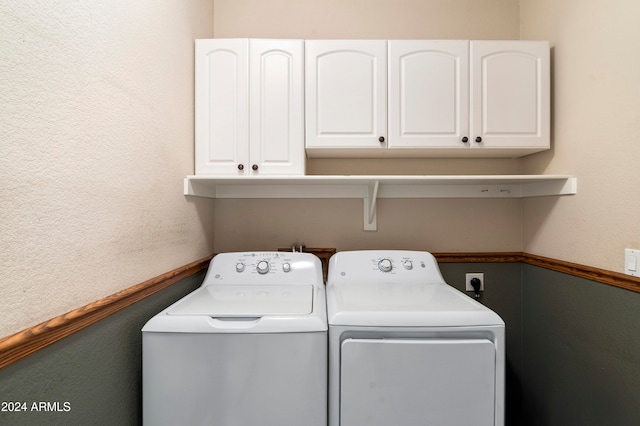 washroom with washing machine and clothes dryer and cabinets