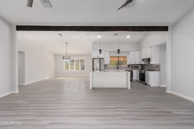 kitchen with stainless steel appliances, white cabinetry, a kitchen island, and hanging light fixtures