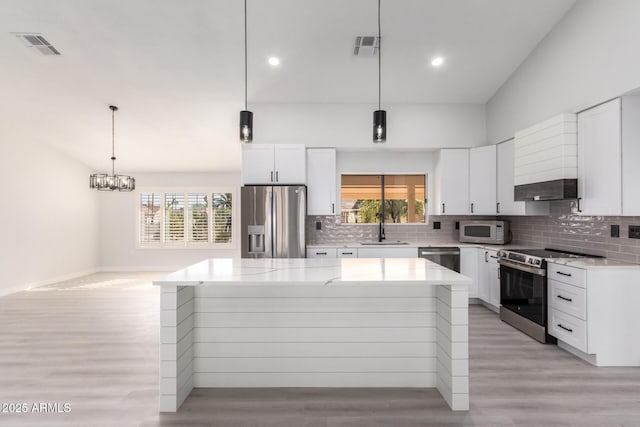 kitchen featuring a kitchen island, appliances with stainless steel finishes, and white cabinetry