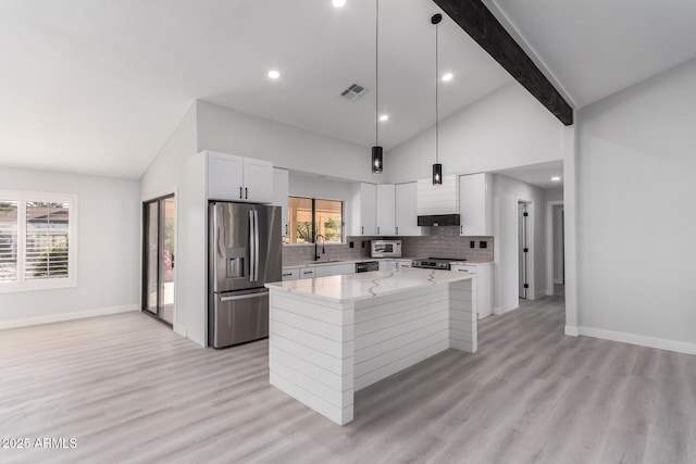 kitchen with stainless steel appliances, sink, white cabinetry, a kitchen island, and pendant lighting