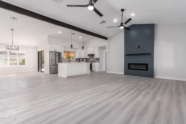 unfurnished living room featuring ceiling fan with notable chandelier, light hardwood / wood-style floors, a large fireplace, and sink