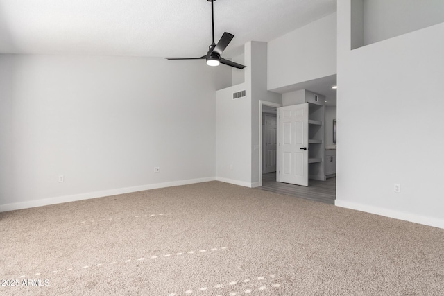 interior space featuring a high ceiling, ceiling fan, and carpet