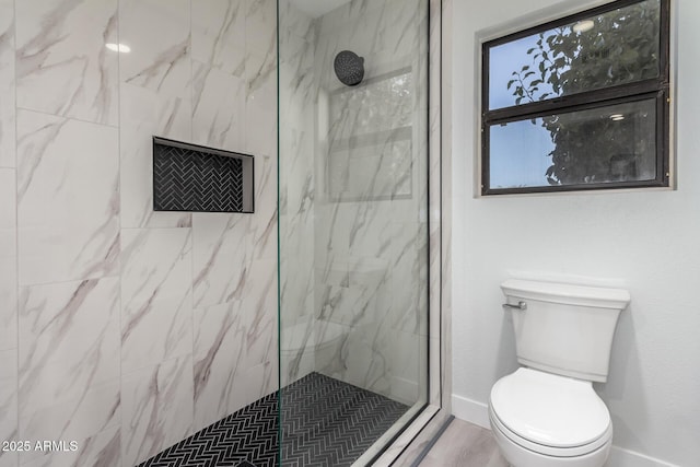 bathroom featuring toilet and a tile shower